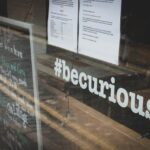 Uma montra de loja com a inscrição "#becurious".
