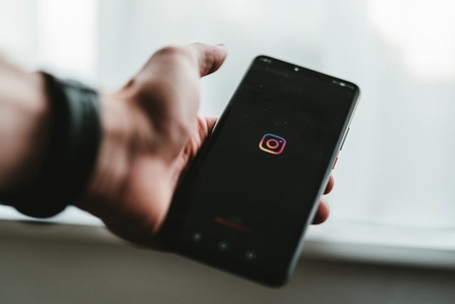 Uma pessoa segura um smartphone com o Instagram a carregar no ecrã.