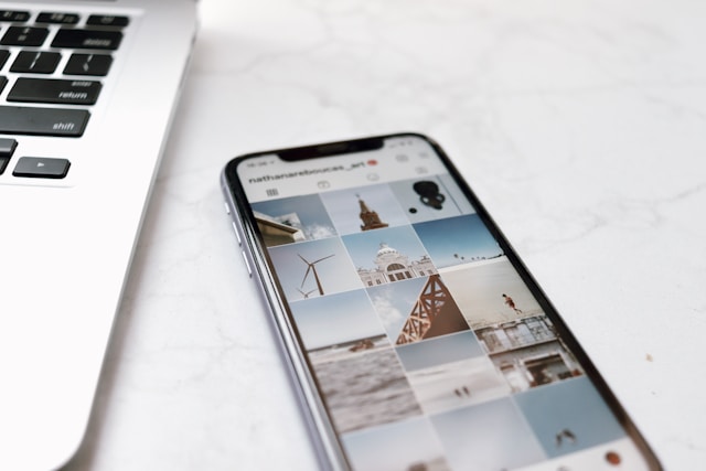 Um computador portátil e um smartphone ao lado mostram várias fotografias.