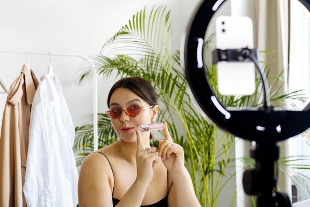 Uma influenciadora de maquilhagem a exibir um produto cosmético.