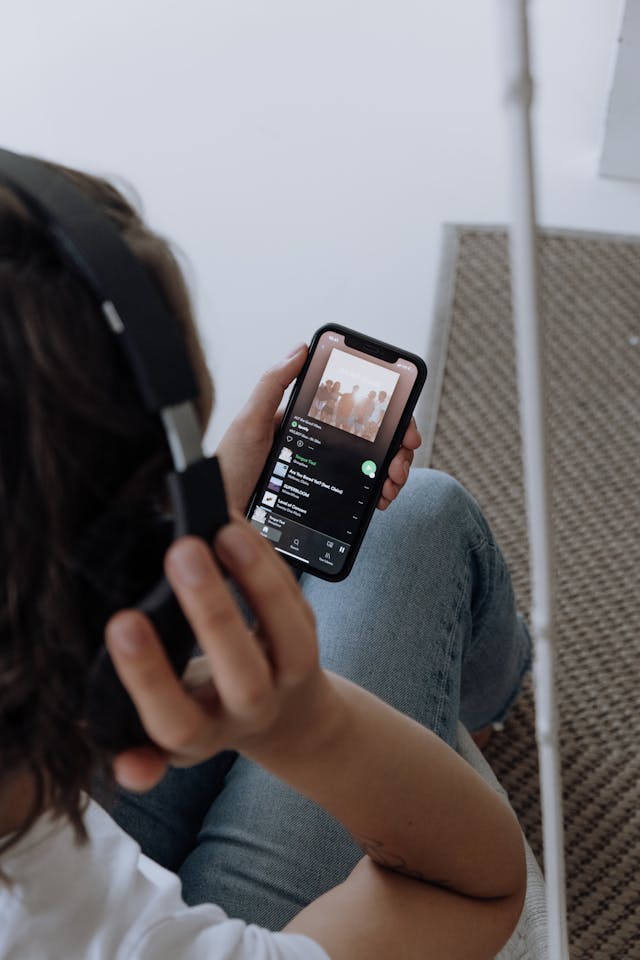 Uma pessoa com auscultadores a ouvir uma lista de reprodução do Spotify.