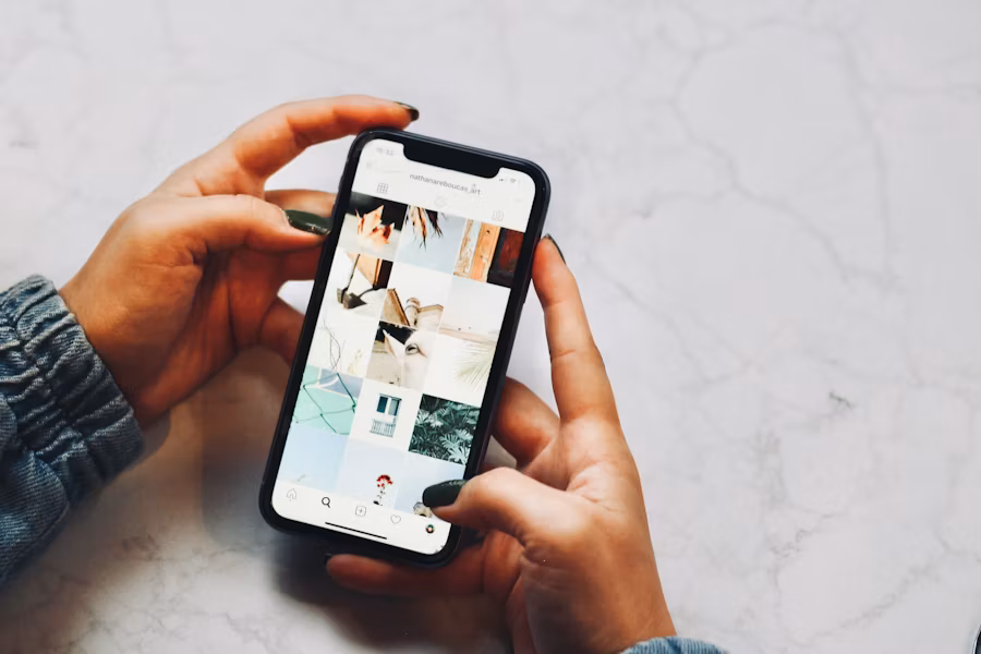 O persoană ține în mână un smartphone care afișează postările de pe un cont Instagram.