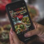 O persoană fotografiază o varietate de feluri de mâncare.